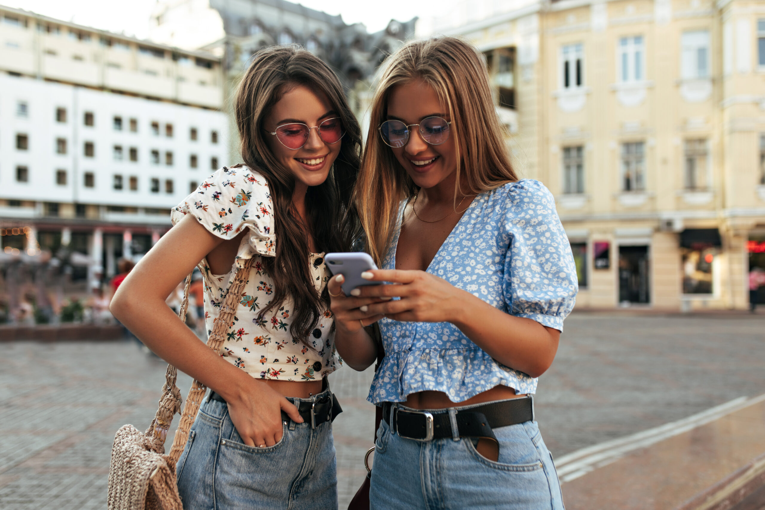 Dvije djevojke koriste pametni telefon i uspoređuju mogućnosti mobitela